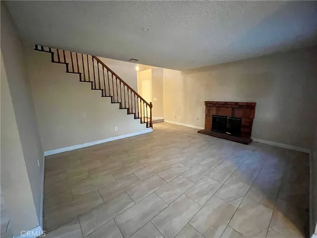 a view of empty room with a fireplace and a window