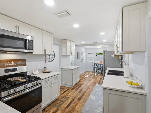 a kitchen with a stove a sink and a microwave