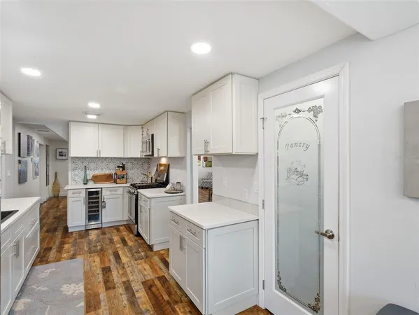 a kitchen with appliances a sink and cabinets