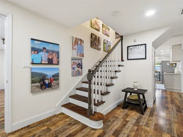 a view of a hallway with a white walls and wooden floor