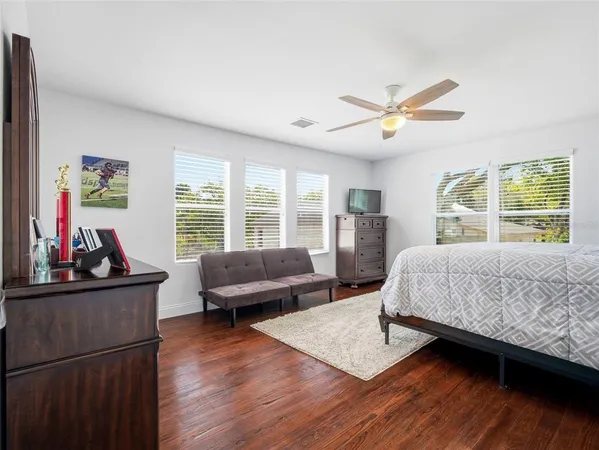 a bedroom with a bed wooden floor and window