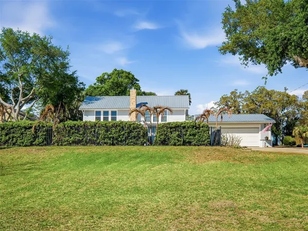 a view of a house with a big yard and a large tree