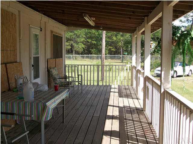 11380 6 Pack Road Milton, FL 32583 - Photo 4 of 22 Front porch with plenty of space to have patio funiture and still walking room. Boards on windows for hurricane season