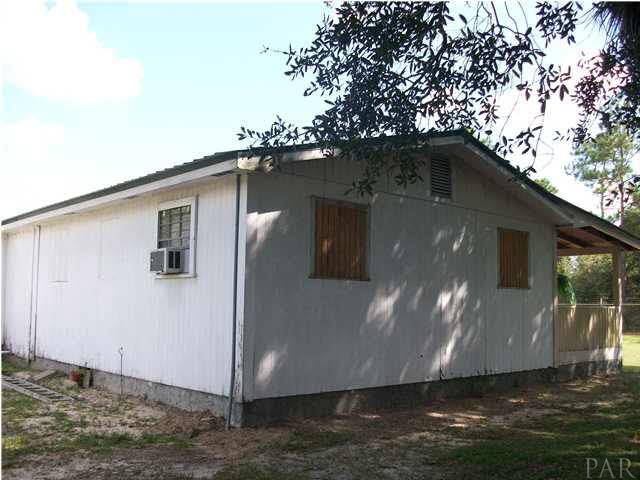 11380 6 Pack Road Milton, FL 32583 - Photo 8 of 22 Some windows are boarded for hurricane season.