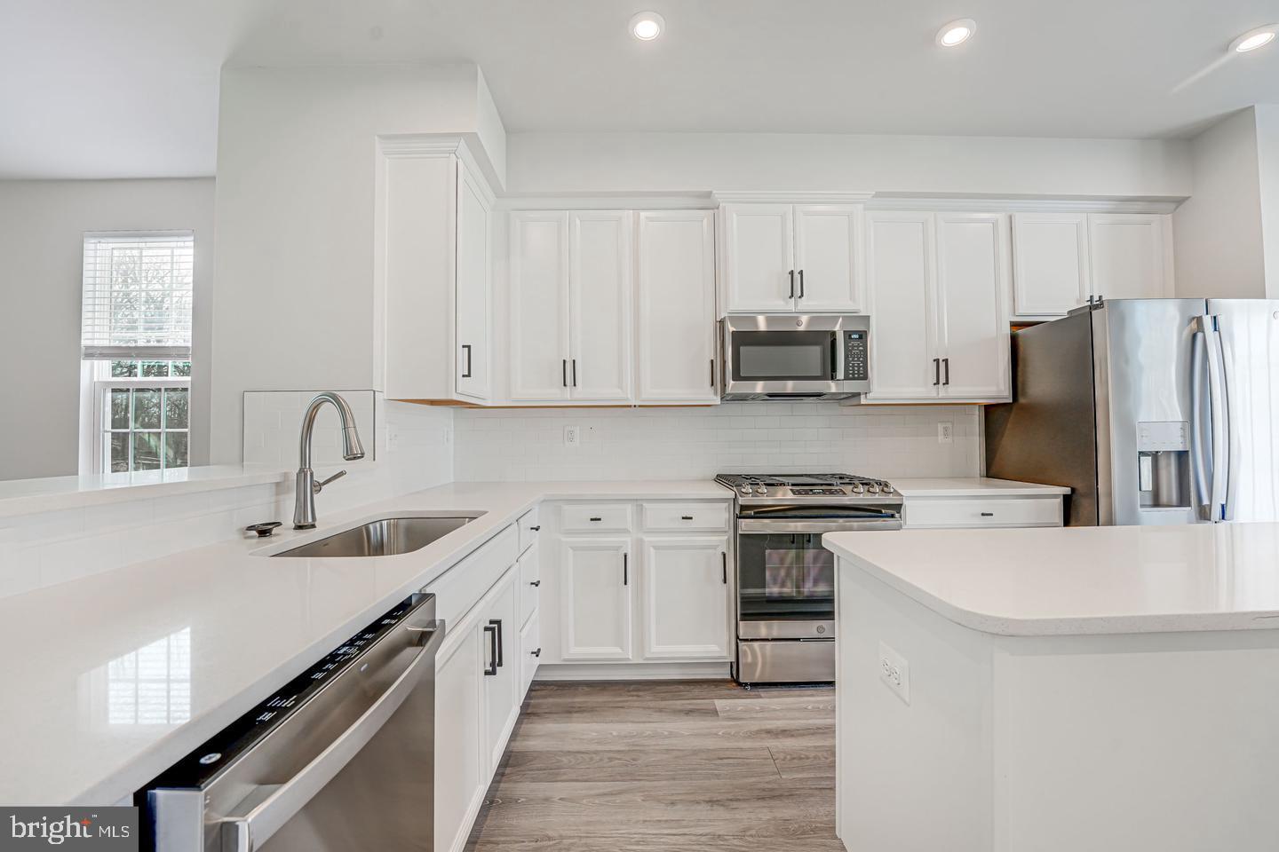 18339 Reaper Hl Court Triangle, VA 22172 - Photo 14 of 34 a kitchen with refrigerator a stove and a sink