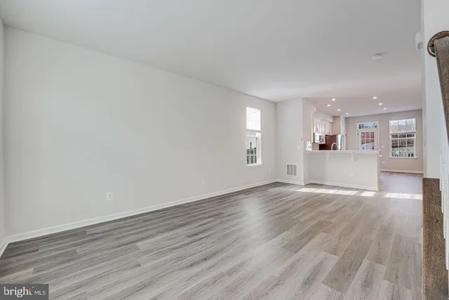 a view of a kitchen with wooden floor and a window