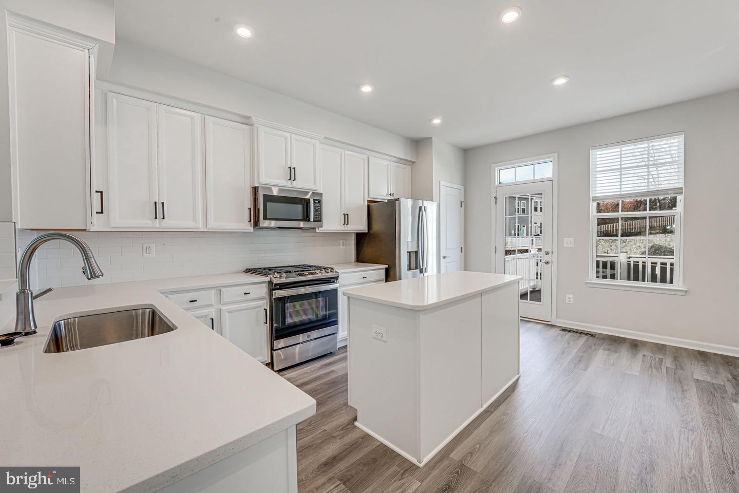 18339 Reaper Hl Court Triangle, VA 22172 - Photo 17 of 34 a kitchen with stainless steel appliances granite countertop a sink stove and refrigerator