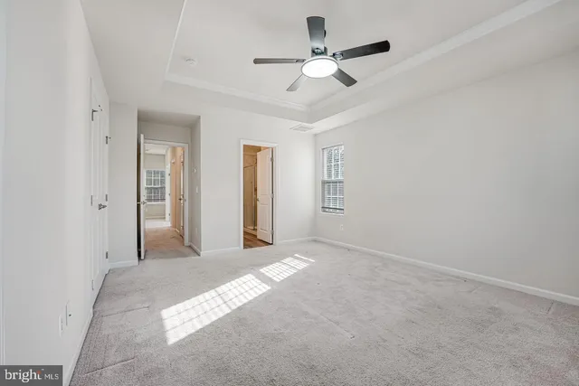 an empty room with chandelier fan