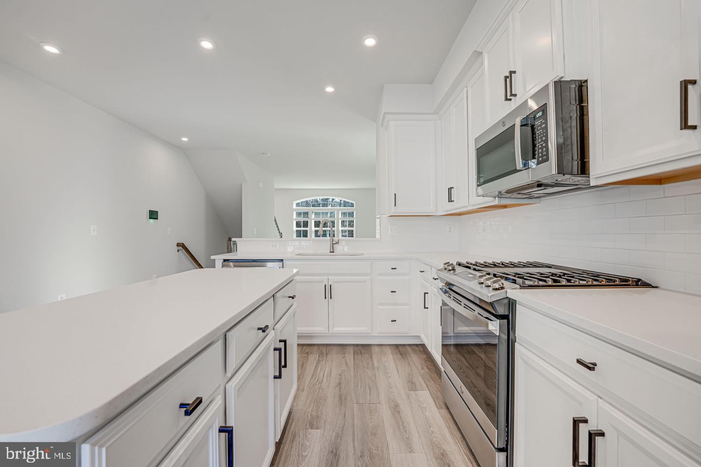 18339 Reaper Hl Court Triangle, VA 22172 - Photo 21 of 34 a kitchen with white cabinets and appliances