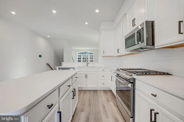 a kitchen with white cabinets and appliances