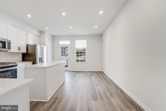 a view of kitchen with sink microwave refrigerator and cabinets