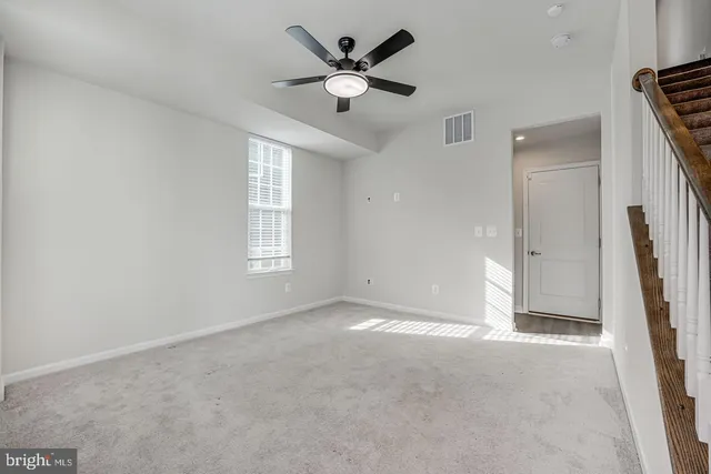 an empty room with closet and a ceiling fan