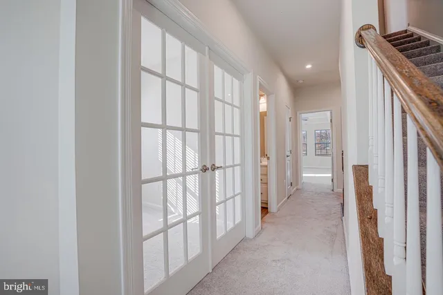 a view of a hallway with wooden floor and bathroom