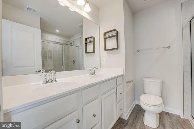 a bathroom with a toilet a sink a mirror and vanity