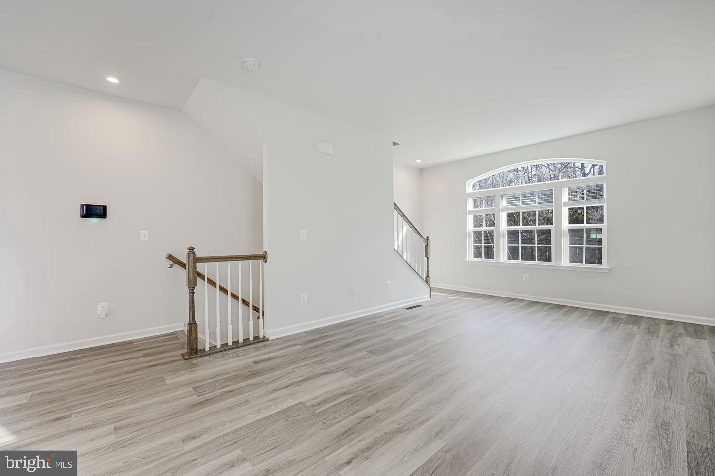 18339 Reaper Hl Court Triangle, VA 22172 - Photo 3 of 34 a view of an empty room with wooden floor and a window