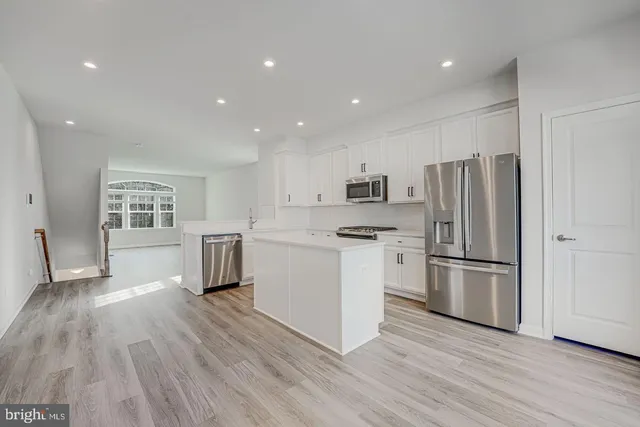 a kitchen with a refrigerator and a stove top oven