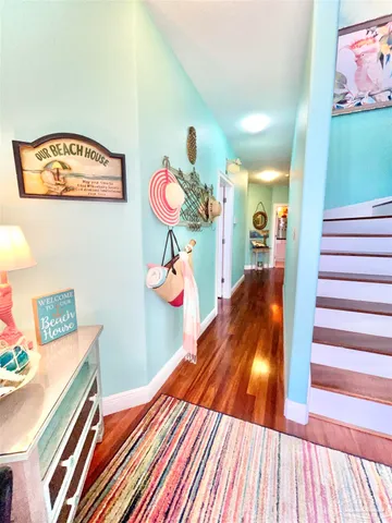 a view of a hallway with furniture and wooden floor