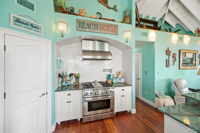 a kitchen with stainless steel appliances a stove and a wooden floor