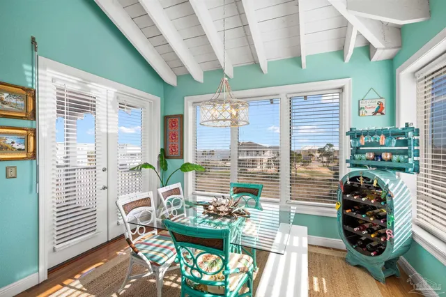 a dining room with furniture and a floor to ceiling window
