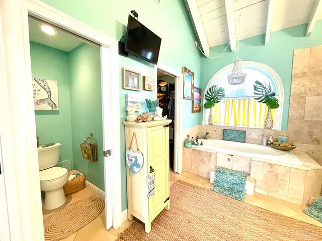 a spacious bathroom with a tub sink and a mirror