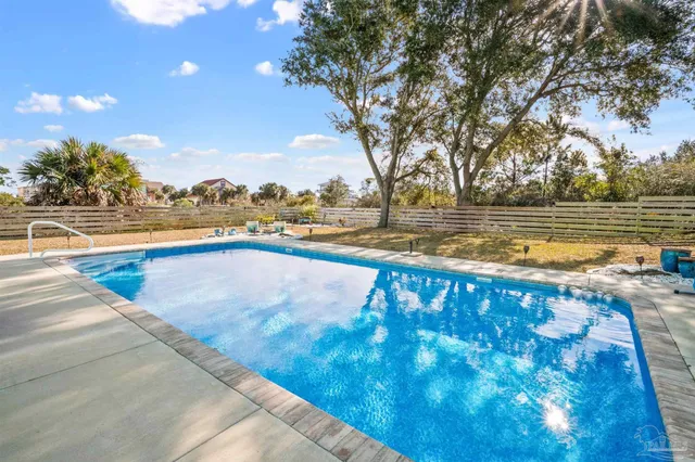 a view of swimming pool with outdoor seating and yard in the back
