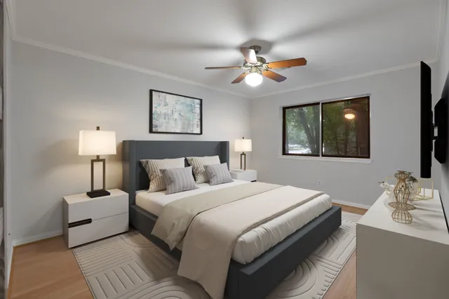 an empty room with wooden floor closet and fan