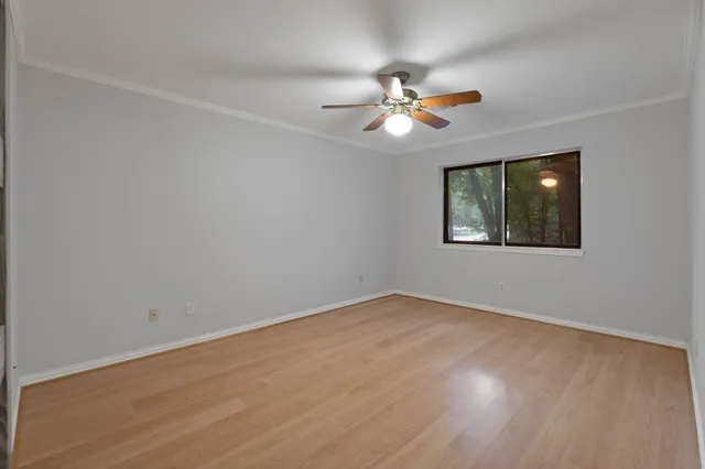 wooden floor in an empty room with a fan