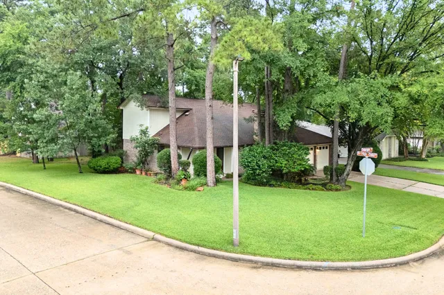 a view of an empty room with wooden floor and a fireplace