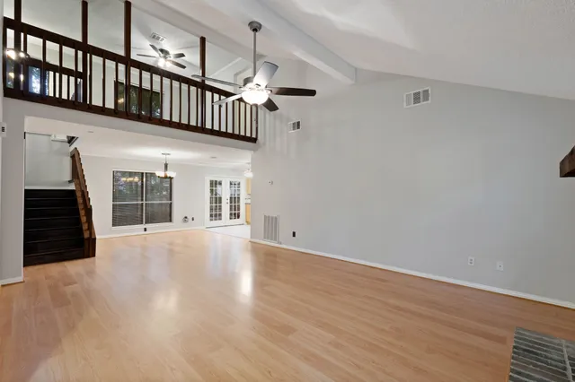 a large kitchen with granite countertop a stove a sink dishwasher and a refrigerator with wooden floor