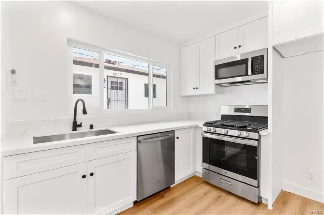 a kitchen with cabinets stainless steel appliances and a sink