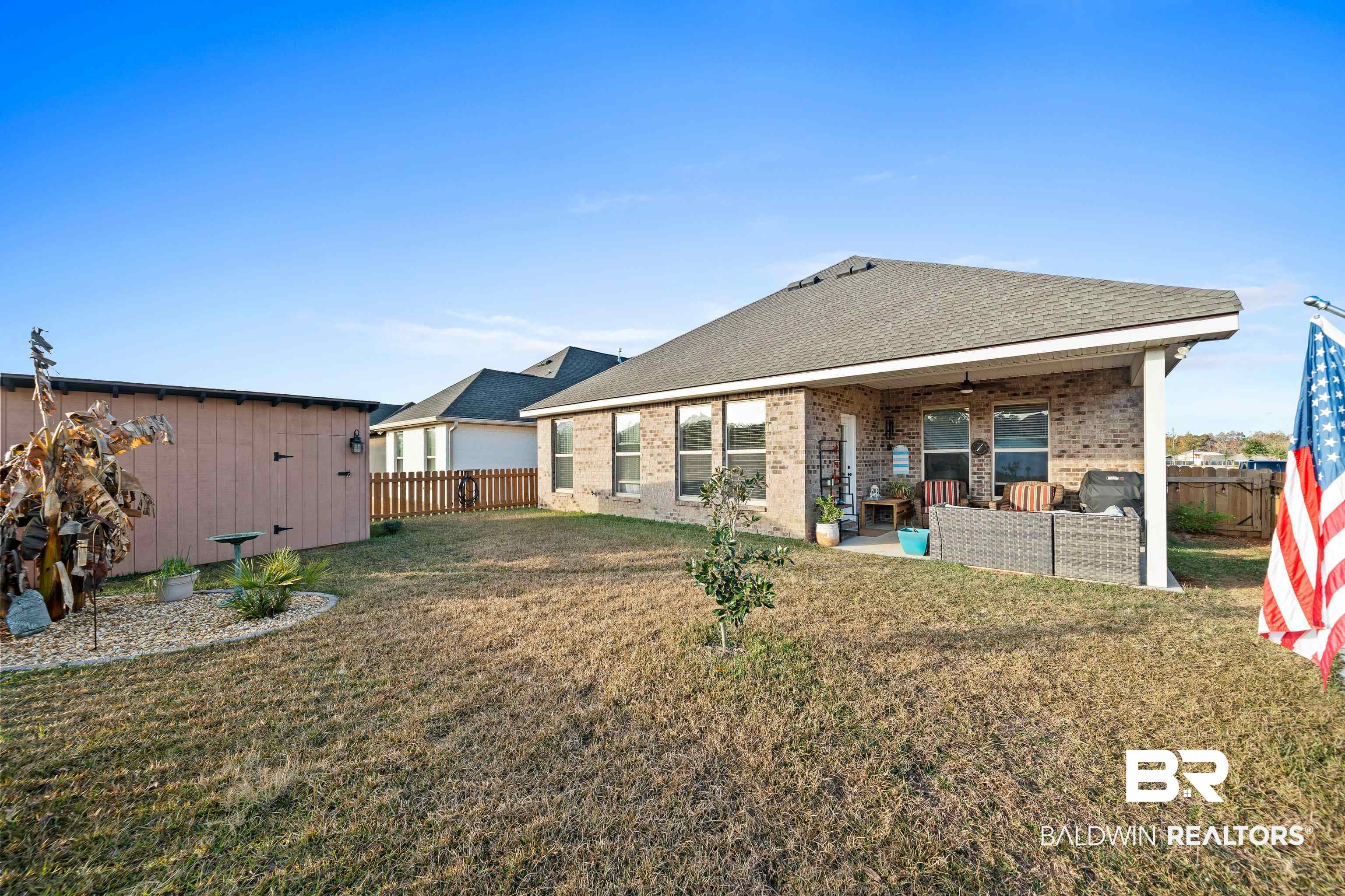 1390 Aldon Street Foley, AL 36535 - Photo 26 of 31 Back of property featuring a ceiling fan, a patio area, roof with shingles, a fenced backyard, and brick siding