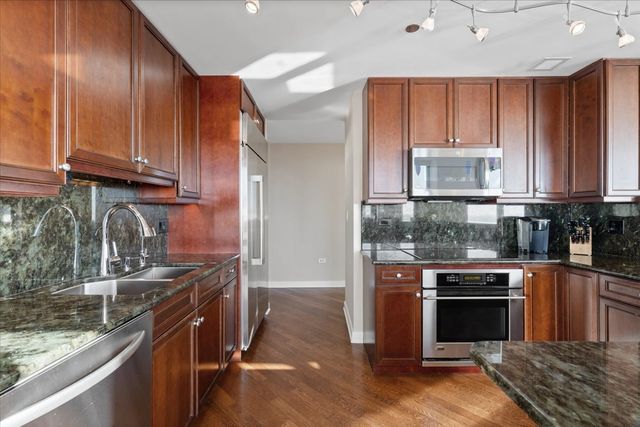 a kitchen with a sink refrigerator and cabinets