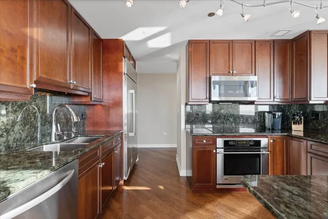 a kitchen with a sink refrigerator and cabinets