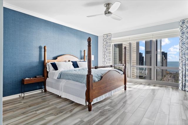 a bedroom with a large bed and a flat tv screen on dresser