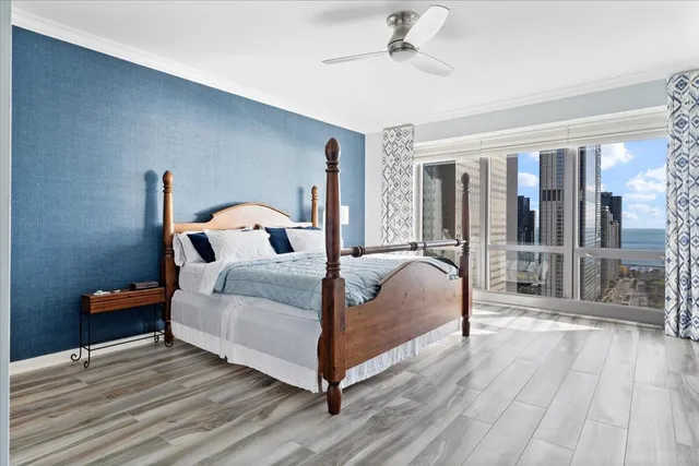 a bedroom with a large bed and a flat tv screen on dresser