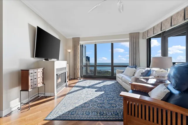 a living room with furniture a flat screen tv and a floor to ceiling window