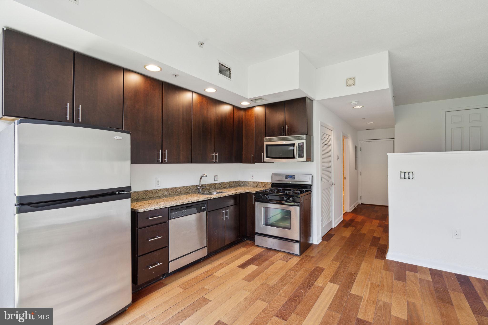 22 South Front Street, Unit 304 Philadelphia, PA 19106 - Photo 4 of 20 a large kitchen with stainless steel appliances sink a microwave and cabinets