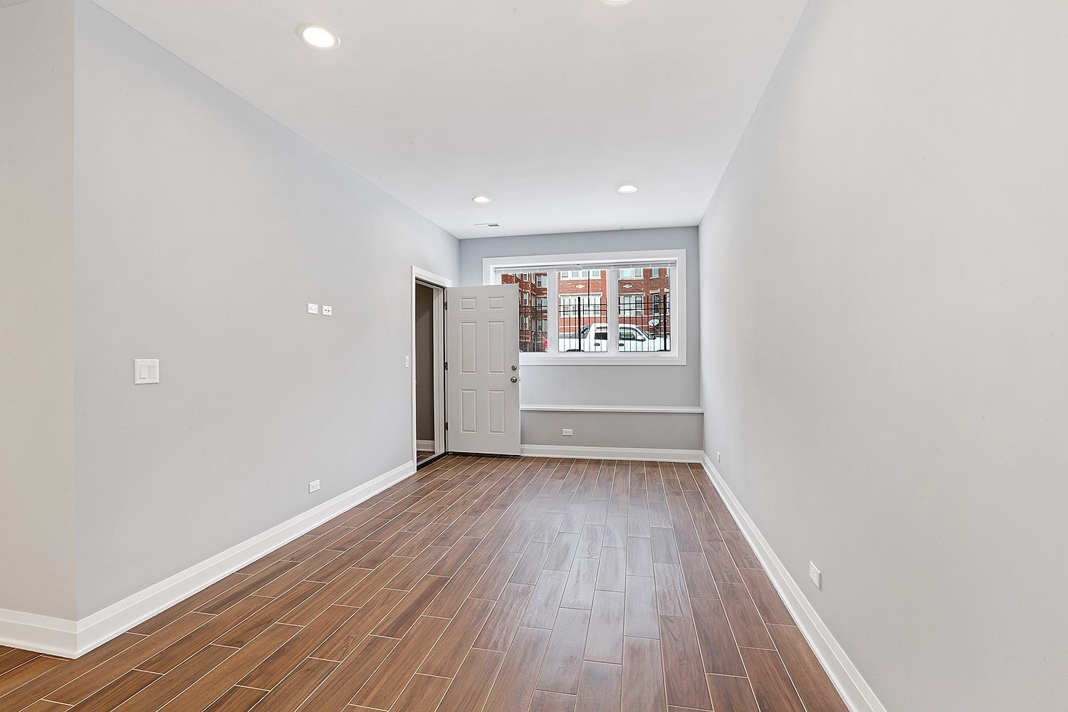 5955 West Superior Street, Unit G Chicago, IL 60644 - Photo 2 of 6 a view of a big room with wooden floor and windows