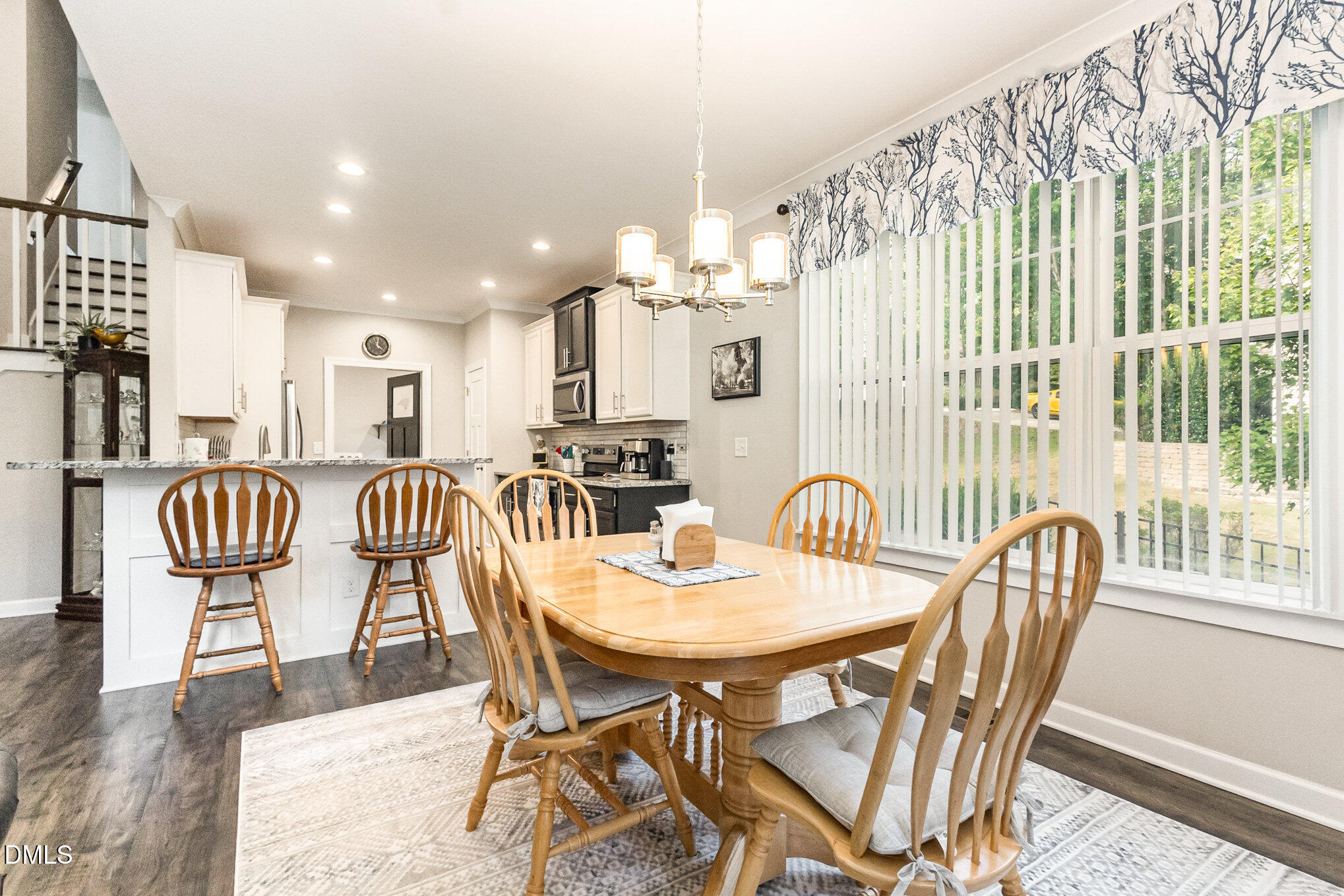 128 Waterleaf Place Clayton, NC 27527 - Photo 17 of 57 a view of a dining room with furniture a chandelier and wooden floor
