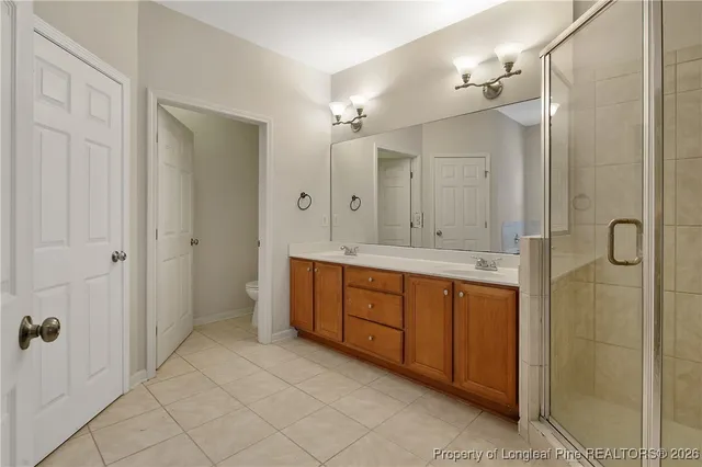 a bathroom with a double vanity sink a toilet and a mirror