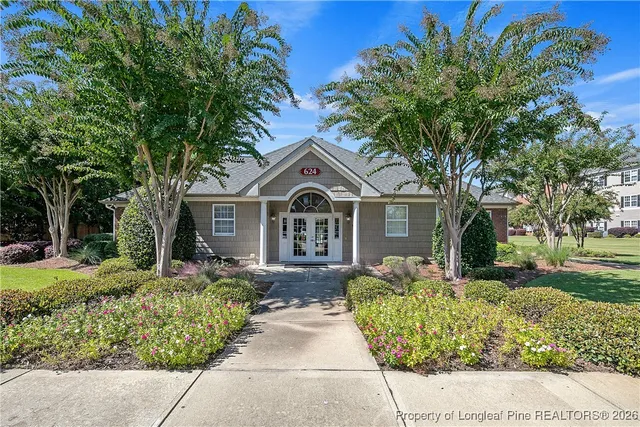 a front view of a house with a yard and trees