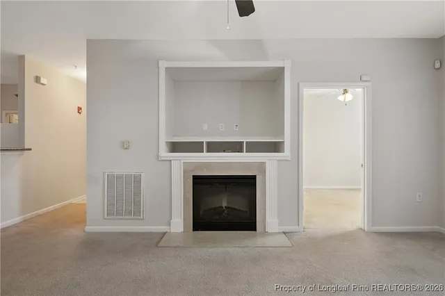a view of a livingroom with a fireplace and a ceiling fan