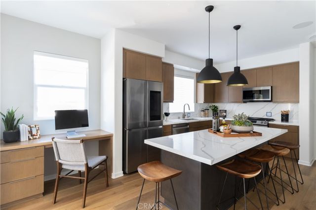 a kitchen with a dining table chairs a sink dishwasher refrigerator and microwave