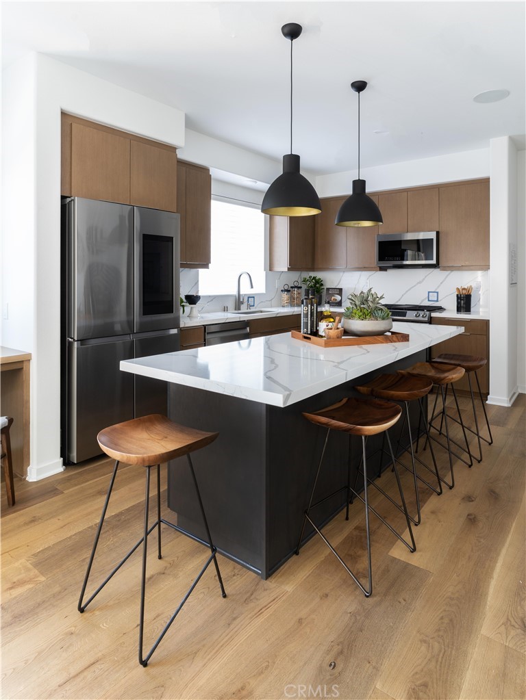 1479 Azalea Circle Gardena, CA 90247 - Photo 13 of 33 a kitchen with stainless steel appliances kitchen island granite countertop a sink a stove and a wooden floors