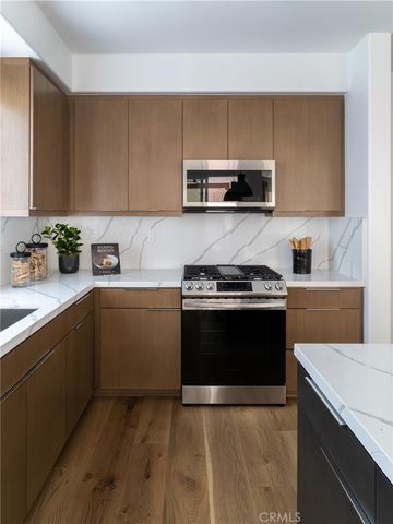a kitchen with stainless steel appliances a sink dishwasher stove and microwave with wooden cabinets