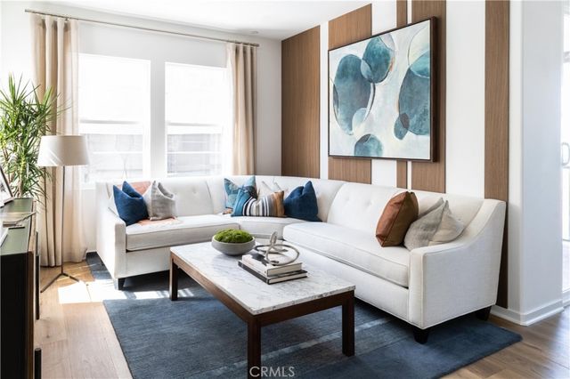a living room with furniture and a large window with wooden floor