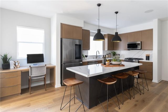 a kitchen with stainless steel appliances kitchen island granite countertop a sink a stove and a refrigerator