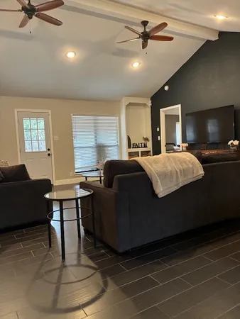 a living room with furniture a flat screen tv and a fireplace