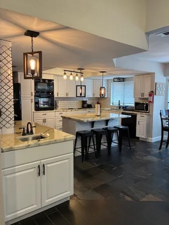 a kitchen with stainless steel appliances granite countertop a sink a stove top oven a counter space and cabinets