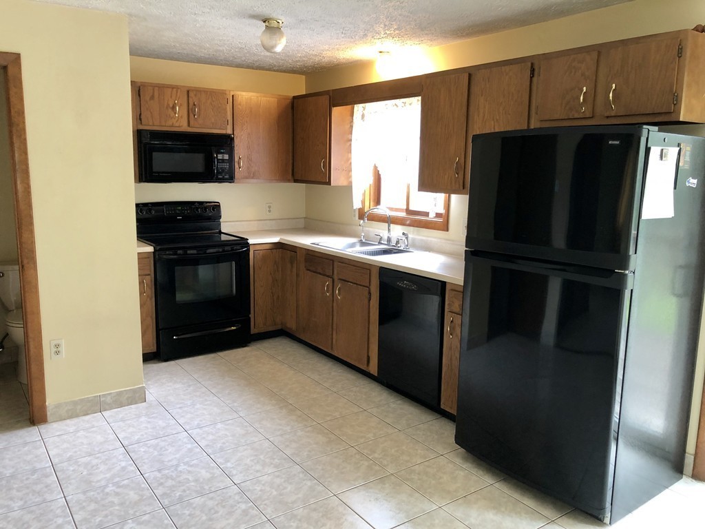 11 R Gamache Road, Unit 11R Derry, NH 03038 - Photo 7 of 20 a kitchen with stainless steel appliances granite countertop a refrigerator and a stove